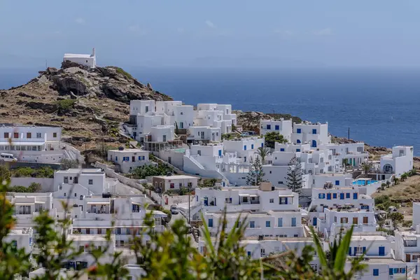 stock image Ios, Greece - May 4, 2024 : View of various whitewashed hotels, a church on the top of the hill and the Aegean Sea in the background in Ios Greece