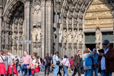 Köln, Almanya - 22 Mayıs 2024: Köln Almanya 'sında Aziz Peter Köln Katedrali' nin etkileyici girişinin önündeki turist görüntüsü