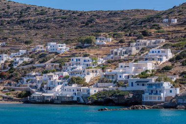 Sikinos Yunanistan 'da bir plajın yanındaki çeşitli badanalı binaların manzarası