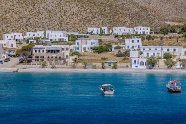Folegandros, Yunanistan - 6 Mayıs 2024: Sifnos Yunanistan limanı yakınlarındaki çeşitli tekneler ve güzel bir plaj manzarası