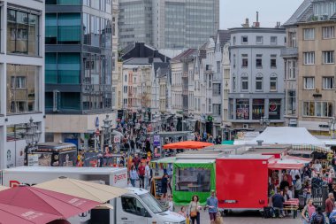 Bonn, Almanya - 21 Mayıs 2024: Bonn Almanya 'daki pazar meydanının panoramik manzarası çeşitli gıda kamyonları, kafeler, dükkanlar, restoranlar ve günün tadını çıkaran insanlar