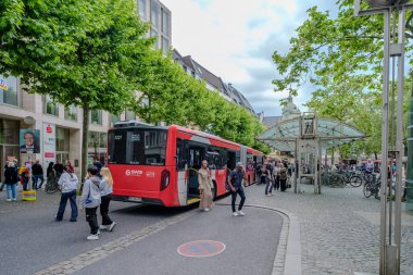 Bonn, Germany : May 21, 2024 : View of public buses arriving and letting people get off and on at the Friedensplatz in Bonn Germany clipart