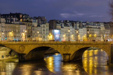 Paris, France - December 1, 2024 : View of the illuminated Saint Michel bridge and the Seine river at the popular area of Saint Michel in Paris France clipart