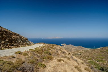 Yunanistan 'ın arka planında ıssız bir yol ve Ege Denizi manzarası