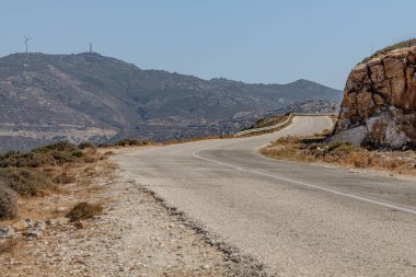 Yunanistan 'daki kayalık tepelerin yanında boş ve ıssız bir yol manzarası