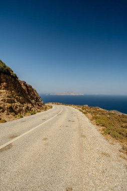 Yunanistan 'ın arka planında ıssız bir yol ve Ege Denizi manzarası