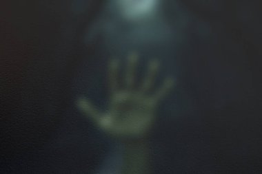 Gece ormanı arka planında, camın arkasında korkunç bir sahne, bulanık etki