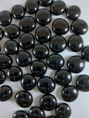 Mermer çakıl taşları, doğal siyah renk, yuvarlak kesir, doku, zarif arkaplan.