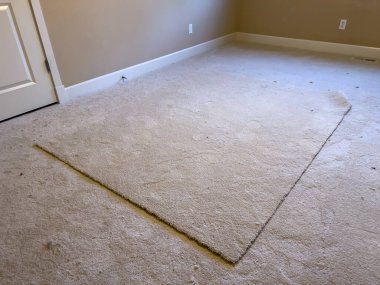 Wide angle view of a large square of carpet in the middle of an empty bedroom clipart