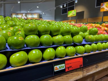 Mill Creek, WA USA - Kasım 2022: Parlak, geniş görünüm bir kasaba ve ülke pazarı içinde satılık nine demirci elmaları.