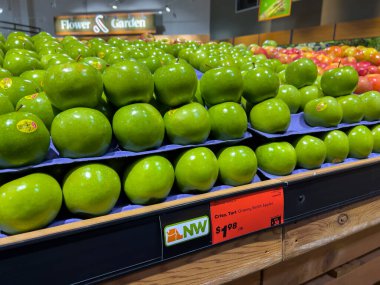 Mill Creek, WA USA - Kasım 2022: Parlak, geniş görünüm bir kasaba ve ülke pazarı içinde satılık nine demirci elmaları.