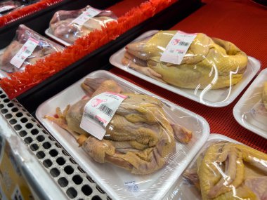Lynnwood, WA USA - Kasım 2022: H Mart marketinde paketlenmiş bütün bir çiğ tavuğun yakın görüntüsü.