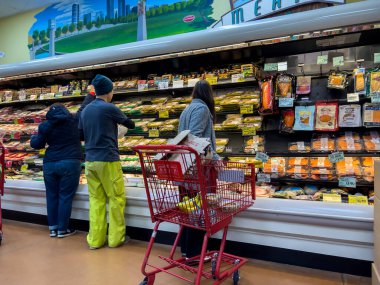 Bellevue, WA USA - Aralık 2022: Bir Tüccar Joes marketinin soğutulmuş gıda reyonundan alışveriş yapan insanların geniş görünümü.
