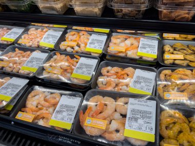 Woodinville, WA USA - Aralık 2022: Yakın plan, Haggen marketinin soğutulmuş bölümünde satılacak paketlenmiş çiğ karideslere odaklanma.