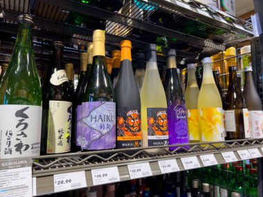 Mill Creek, WA USA - Nisan 2022: Bir kasaba ve ülke bakkalının likör bölümünde satılık çeşitli sake çeşitlerine odaklı