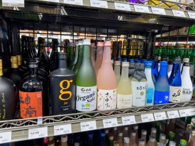Mill Creek, WA USA - Nisan 2022: Bir kasaba ve ülke bakkalının likör bölümünde satılık çeşitli sake çeşitlerine odaklı