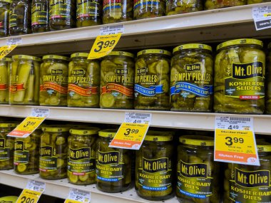 Seattle, WA USA - circa August 2022: Close up, selective focus on jarred pickles for sale inside a QFC grocery store