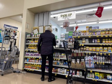 Everett, WA USA - Aralık 2022: Albertsons Eczanesi 'nden reçete alan yaşlı bir kadının geniş görüşü.