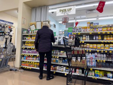 Everett, WA USA - Aralık 2022: Albertsons Eczanesi 'nden reçete alan yaşlı bir kadının geniş görüşü.