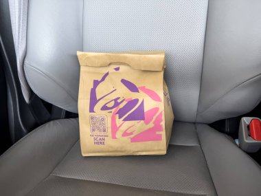 Seattle, WA USA - takriben Mart 2023: Bir arabanın içindeki Taco Bell fast food çantasının yakın görüntüsü.