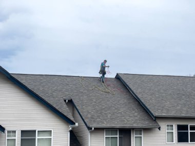 Mill Creek, WA USA - Mart 2023: Bulutlu bir günde bir apartmanın çatı malzemelerini tamir etmeye çalışan çatı ustalarının geniş görünümü