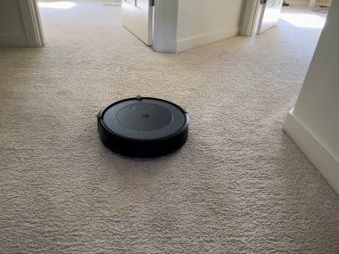 Seattle, WA USA - Mayıs 2023: Bir iRobot Roomba 'nın aydınlık halı döşeli bir evdeki görüntüsünü kapat.