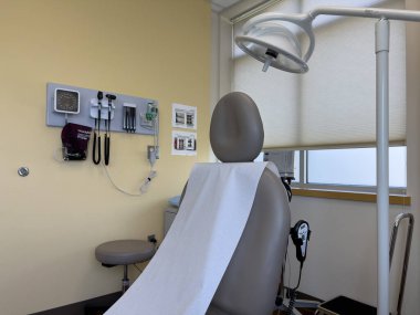 Everett, WA USA - 5 Haziran 2024: Bir doktor ofisinde boş ve temiz bir tıbbi sandalye görmek.