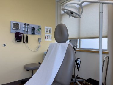 Everett, WA USA - 5 Haziran 2024: Bir doktor ofisinde boş ve temiz bir tıbbi sandalye görmek.