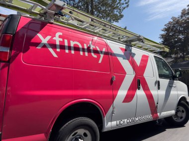 Bothell, WA USA - Ekim 2024: Bir apartman kompleksi otoparkında park edilmiş bir Xfinity kurulum minibüsünün yakın görüntüsü.