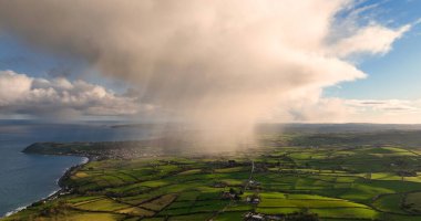 Kuzey İrlanda Antrim 'inde Ballygally üzerinde hafif yağmur bulutları