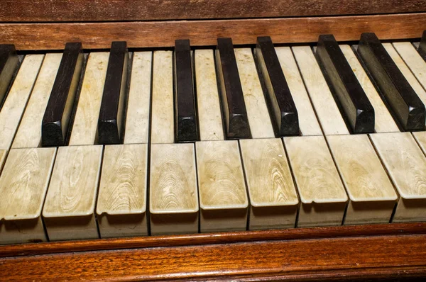 １８０世纪后期 用泥土 汗水和指甲油研磨而成的老式木制大钢琴黑白琴键上的真正的大象象牙钢琴键 弹奏得很好 — 图库照片