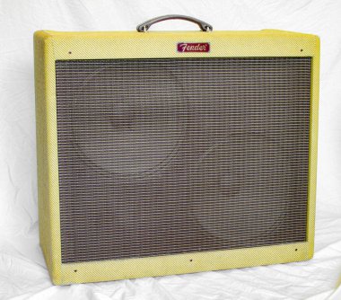 Old vintage retro style fender guitar tube amp or amplifier yellow tweed design with two large speakers visible behind brown grill cover plate.  Isolated on white sheet background Oct 14, 2023 Florida clipart