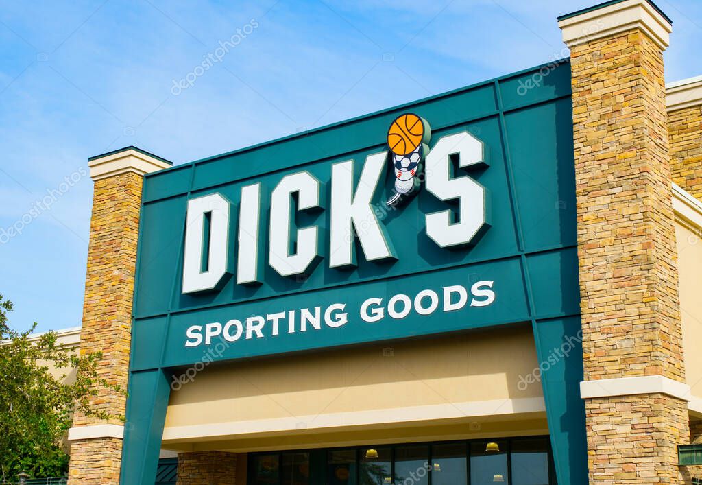 OCALA, FLORIDA USA - OCTOBER 22, 2023 Dicks sporting goods large facade logo sign at entrance to their store. retails athletic apparel, footwear, and equipment for sports. Bright blue sky background