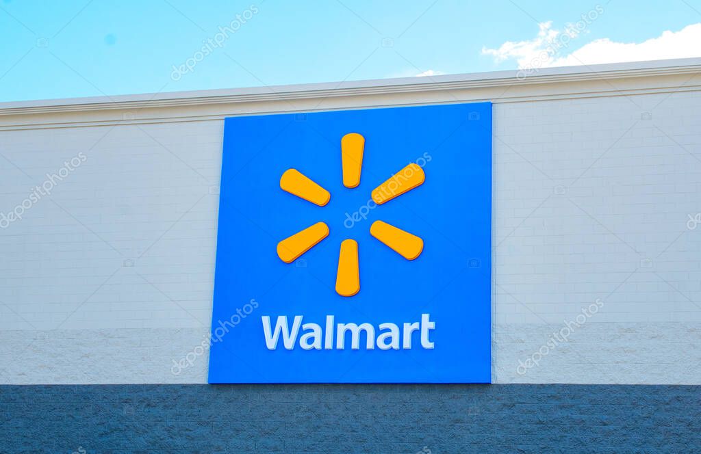 OCALA, FLORIDA USA - OCTOBER 22, 2023 World famous trademark Walmart sign and logo emblem.  Blue background with orange radiating dash, star or spark or sparklets that represents 6 core values