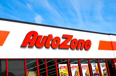 Autozone auto car parts store, OCALA, FLORIDA USA - OCTOBER 22, 2023 front logo facade above entrance.  Exterior view in bright red letters.  Bright blue sky background on a sunny day clipart