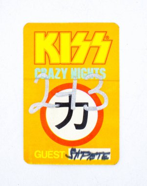 St. Petersburg, Florida USA orange yellow back stage pass for rock band KISS from their 1988 crazy nights world tour with Ted Nugent. Writing in Japanese lettering on emblem design isolated on white clipart