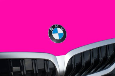 OCALA, FLORIDA - 2 NOVEMBER 2023 BMW logo emblem on deep pink car hood front. Bavaria motor works German multinational manufacturer of luxury vehicles and motorcycles headquartered in Munich, Germany clipart