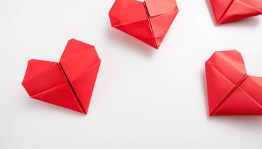 Sevgililer günü kalp konsepti origamisi beyaz zemin üzerinde izole edilmiş çeşitli renklerde kırmızı kağıt kalpler ve Şubat kış tatili için tasarladığınız kopya alanı