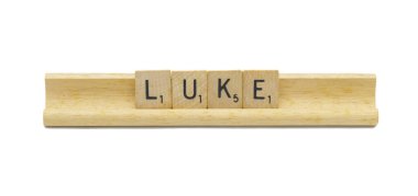 Miami, FL 4-18-24 popular baby boy first name of LUKE made with square wooden tile English alphabet letters with natural color and grain on a wood rack holder isolated on white background clipart