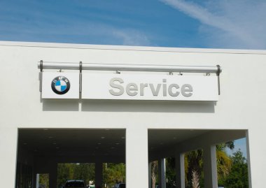 OCALA, FLORIDA - April 28, 2024 BMW logo service center sign at car dealership. Bavaria motor works is a German multinational manufacturer of luxury vehicles and motorcycles headquartered in Germany clipart