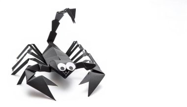 Animal concept paper origami isolated on white background of a scorpion arachnid with claws, pinchers and stinger with copy space, simple starter craft for kids for weekend entertainment clipart