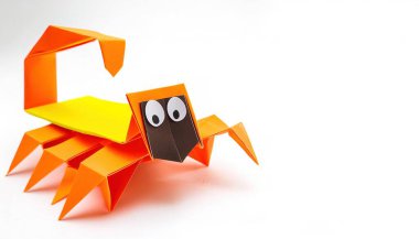 Animal concept paper origami isolated on white background of a scorpion arachnid with claws, pinchers and stinger with copy space, simple starter craft for kids for weekend entertainment clipart