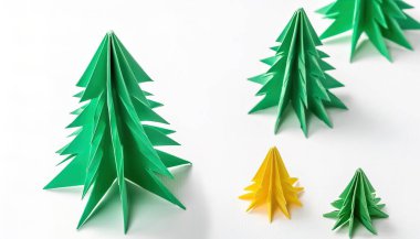 Noel konsepti origami beyaz arka planda izole edilmiş yeşil noel ağacı çeşitli boyut ve renklerde ve Aralık ayındaki kış tatili tasarımınız için fotokopi alanı ile birlikte.