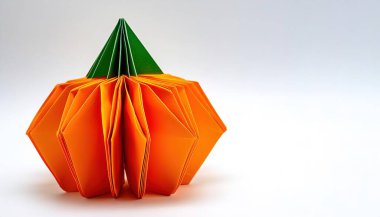 Cadılar Bayramı konsepti origami beyaz arka planda izole edilmiş balkabağı Jack o feneri. Ekim tatili için tasarladığın tasarım için gülümsemeli turuncu balkabağı.