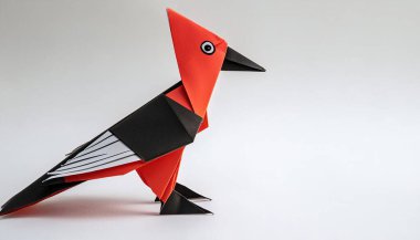 Animal concept origami isolated on white background of a ivory billed woodpecker - Campephilus principalis -  a critically endangered or extinct species. simple starter craft for kids, with copy space clipart