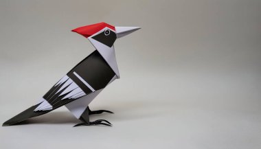 Animal concept origami isolated on white background of a ivory billed woodpecker - Campephilus principalis -  a critically endangered or extinct species. simple starter craft for kids, with copy space clipart