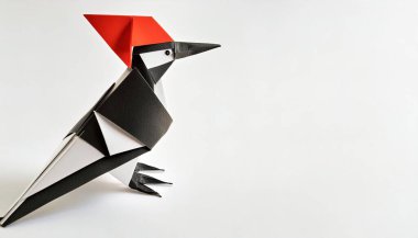 Animal concept origami isolated on white background of a ivory billed woodpecker - Campephilus principalis -  a critically endangered or extinct species. simple starter craft for kids, with copy space clipart