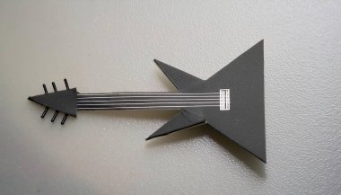 Kağıt origami elektro gitar konsepti, hafta sonu sanat ve el sanatları eğlencesi için çocuklar için basit başlangıç sanatı. Kopyalama alanı olan beyaz bir arkaplanda izole edilmiş