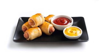 Battaniyedeki domuzlar, hardal ve ketçap soslu aperatif olarak sunulan ayrı ayrı hamur işine sarılmış küçük sosisler veya sosislerdir. Kopya alanı ile beyaz arkaplanda izole