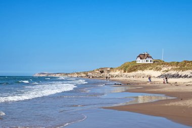 Lokken, Jutland, Danimarka - 04 Haziran 2023: Lokken 'deki kum tepelerinde ve Kuzey Denizi sahillerinde sazdan çatı manzarası